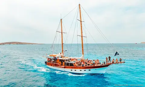 Barca che passa davanti alle grotte marine di Santa Maria sulla costa di Comino